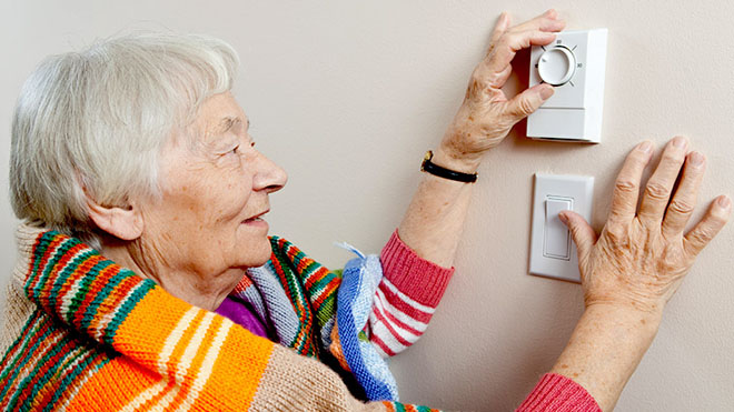 Energy smart woman checking thermostat