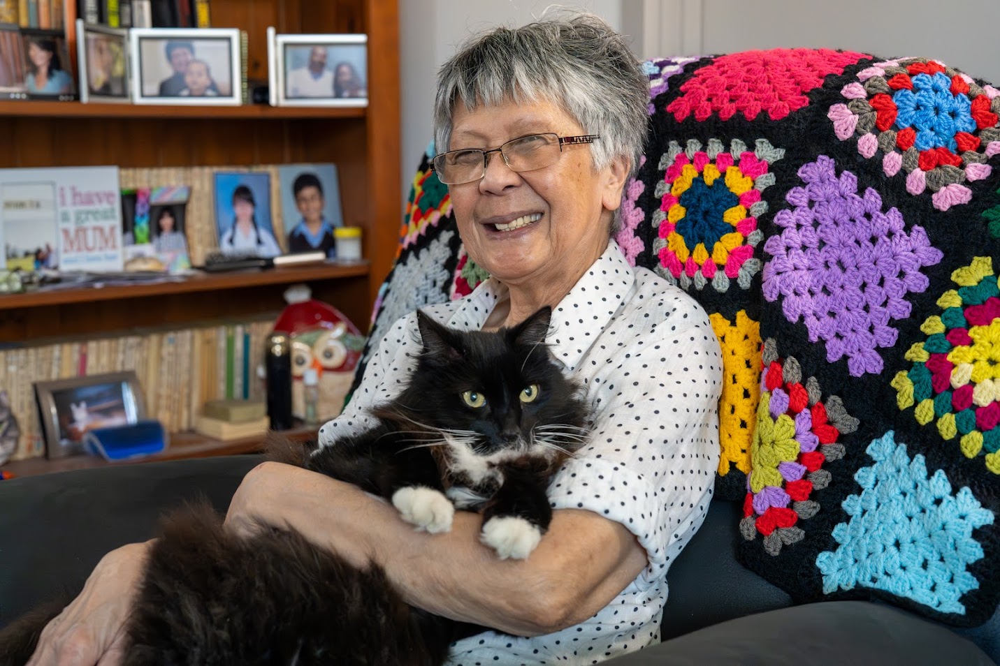 Marcia sitting in a chair holding Buddy the cat 